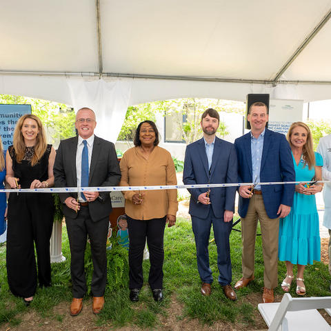 Image of group of people cutting a ribbon to symbolize a new partnership between hospitals