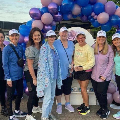 Image of a group of people standing in front of a balloon arch