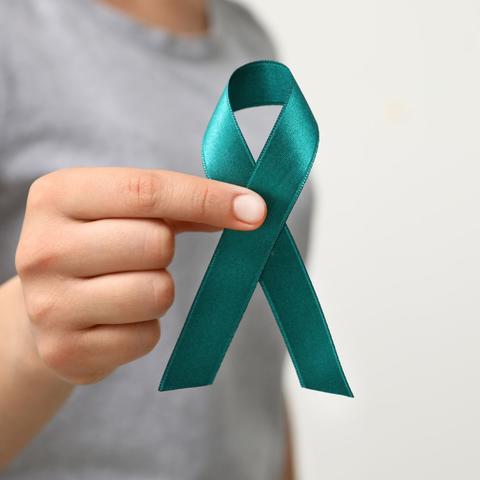 person holding a teal ribbon