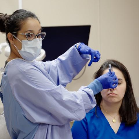 Marcia demonstrating a procedure on a student