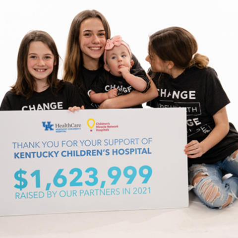 image of family with sign announcing $1,623,999 total from children's miracle network