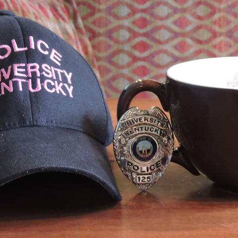photo of UK Police hat and badge and a cup of coffee