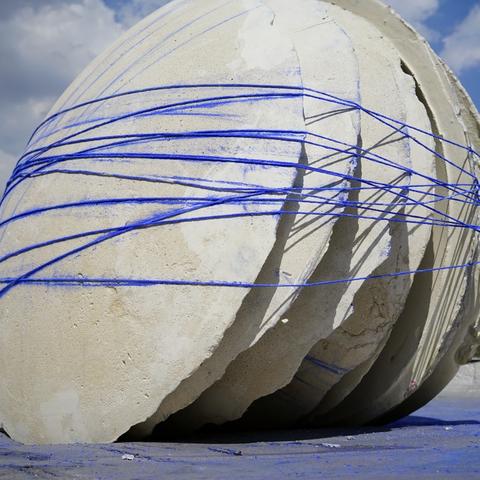 photo of sculptural piece of multiple concrete disks connected to each other with blue rope titled "The Ways We Are" by Crystal Gregory and Alexa Williams
