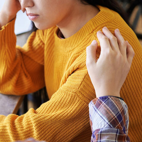 A consoling hand on a shoulder