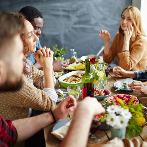 photo of young people around table with food
