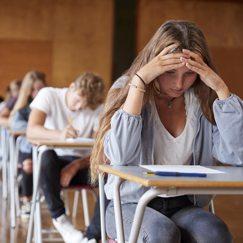 stock photo of female student with head down staring at page on desk