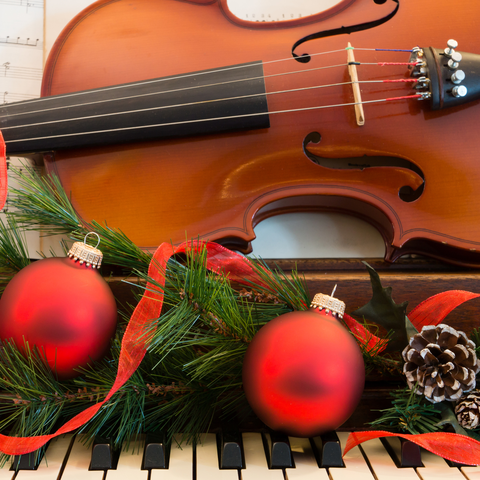 violin on a piano with garland and ornaments