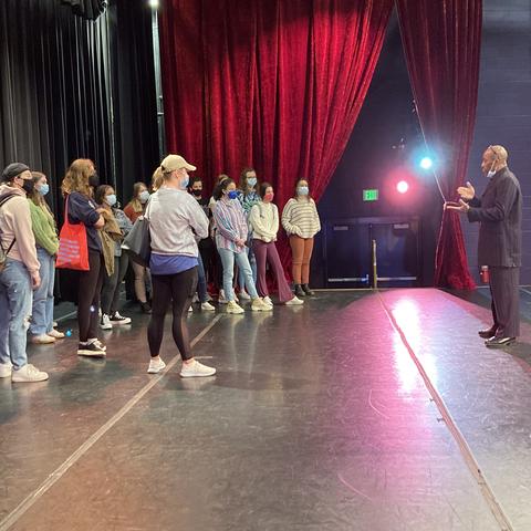 photo of Whit Whitaker (far right) talking to AAD 390 class on The Lyric stage