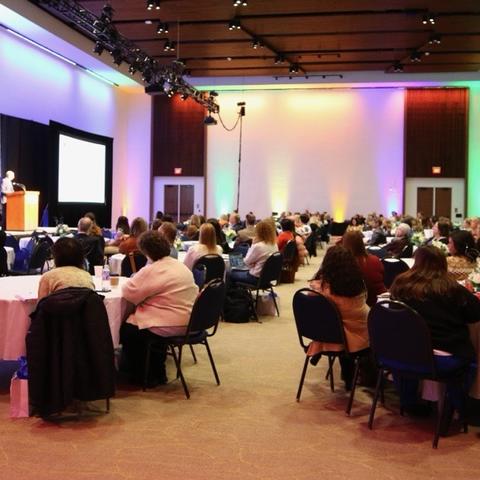 Gill Affiliate Network Conference attendees listen to a presenter in a large ballroom.