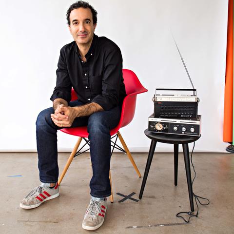 photo of Jad Abumrad seated in red chair next to radio