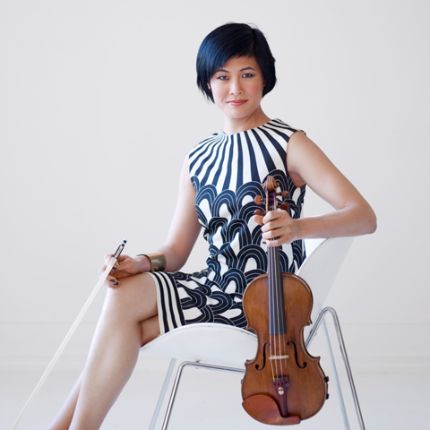 Jennifer Koh seated in chair holding bow and violin