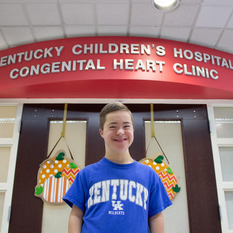 photo of jeremiah in front of the doors to the pediatric heart clinic