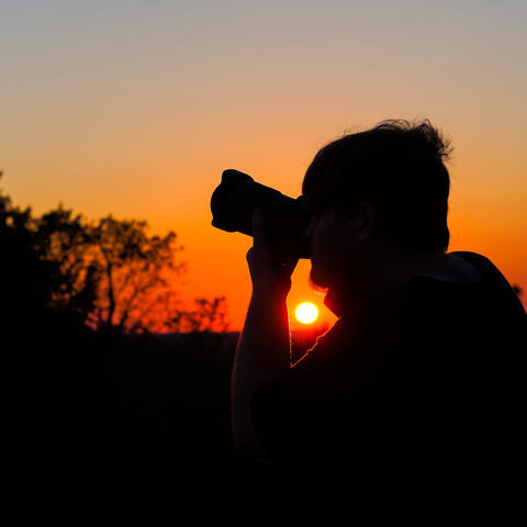 University of Kentucky journalism student Samuel Colmar lines up a shot at sunset during the Picture Kentucky Photojournalism Workshop in Frankfort, Ky., on Oct. 12, 2023. Photo by Carter Skaggs.