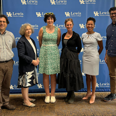 Six professors standing in front of a blue background with UK logos
