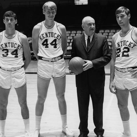 photo of Adolph Rupp (in suit) with basketball players Mike Casey, Dan Issel and Mike Pratt
