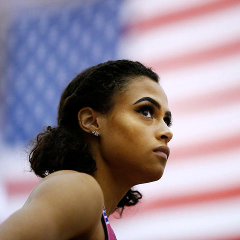 photo of Sydney McLaughlin with American flag behind her