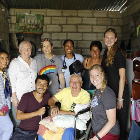 Group of volunteers and community members gathered inside a home for a photo.