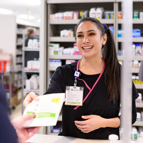 pharmacist handing customer medication
