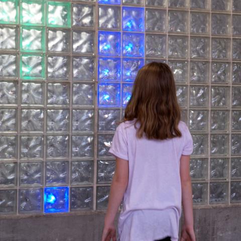 photo of child interacting with LED installation created by UK College of Design