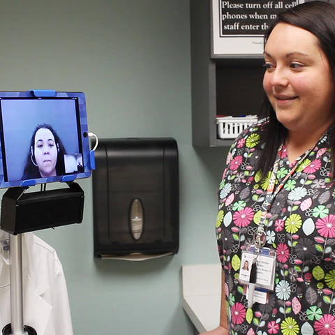 A nurse interacts with the video remote interpreter
