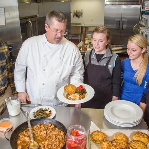 Faculty member Aaron Schwartz, Chef Bob Perry plates a meal with students