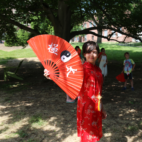 photo of kid with fan dressed in traditional Chinese clothing