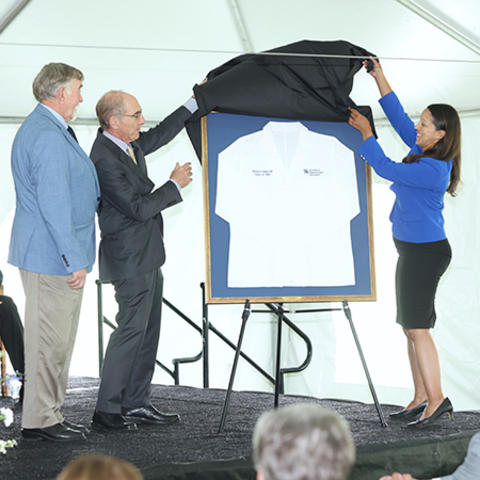 photo of Dr. Capilouto and Dr. Wendy Jackson unveiling medical coat for Dr. Michael D. Rankin