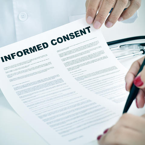 A woman signs an informed consent document