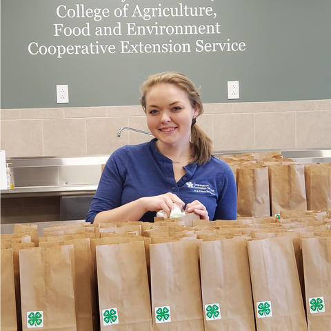 Melissa Schenck poses with brown bags