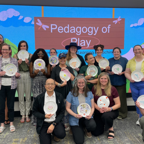 A group of instructors and graduate students holding their creations at the CELT "Pedagogy of Play" event.