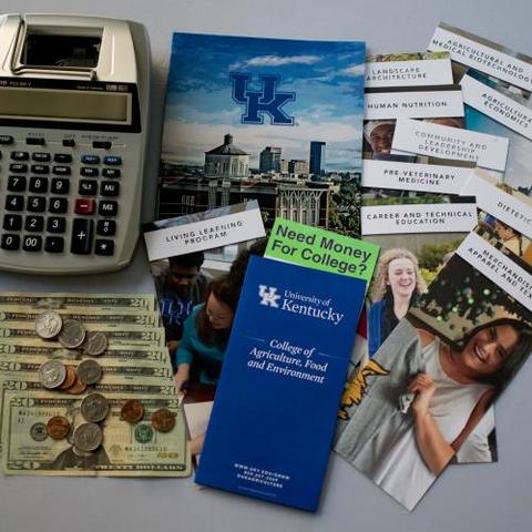 Image of calculator, dollar bills and pamphlets regarding scholarships and the College of Agriculture, Food and Environment