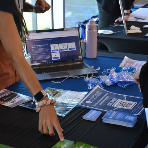 Someone explains resources at a tabling event.