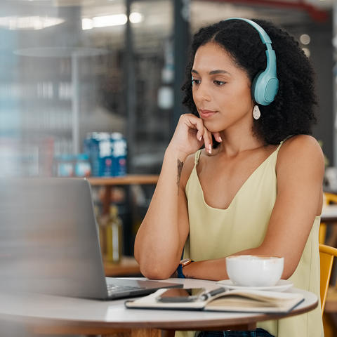 woman sitting in front of a laptop with headphones on