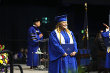 Marilyn Simpson standing with her diploma at Commencement. 