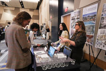 Students speak with representatives at an information booth during a campus career fair.
