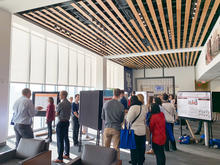 People standing and looking at research project boards. 