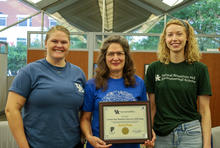 three people holding a certificate 
