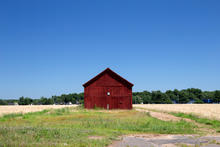 image of a red barn in the daytime with forest in the background