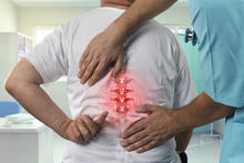 A man points to his back pain. 