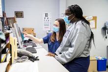 Image of medical students looking at a computer screen in a medical clinic.