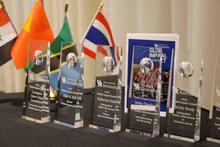University of Kentucky 2025 Global Impact Award trophies displayed on a table with international flags behind them.