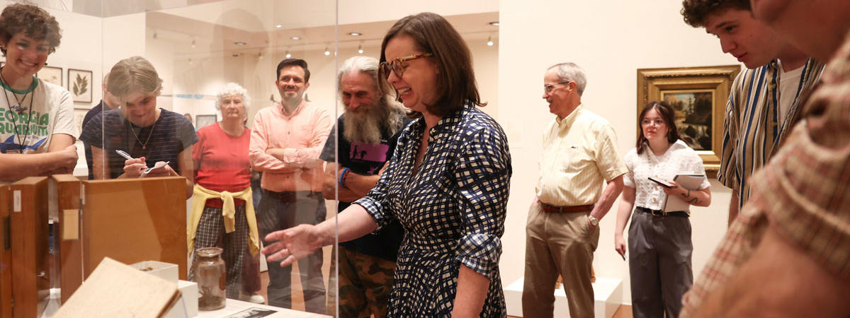 Group tours museum exhibit during gallery discussion.