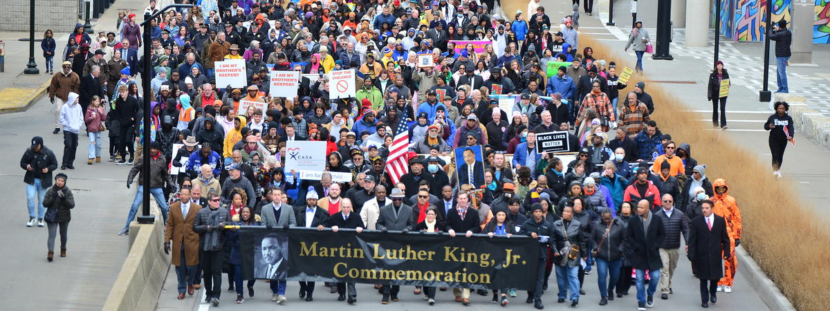 A large crowd of people participating in a Martin Luther King Jr. commemorative march in Lexington, Kentucky.