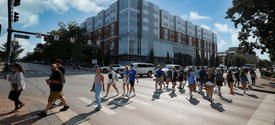 students walking across a crosswalk on campus