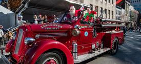 santa riding in a parade on a firetruck
