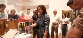 Group tours museum exhibit during gallery discussion.