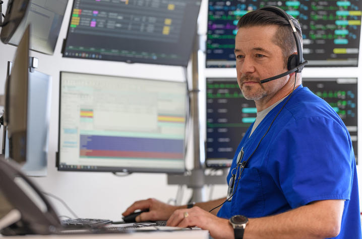 An eICU nurse monitoring patients on computer monitors