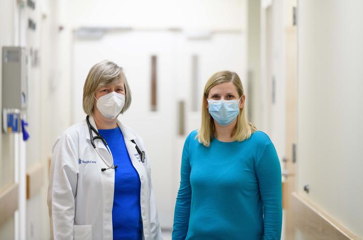 Image of Dr. Birks with Alayna standing in the clinic corridor. 
