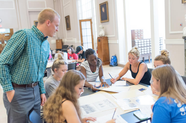 photo of Matthew Strandmark working with students in King Library