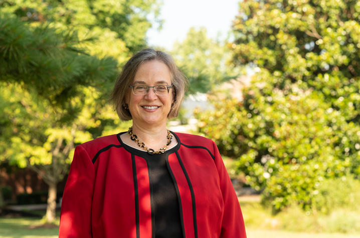 Rebecca Thomas, Ph.D., has served as executive president for academic affairs and dean of the university at Transylvania University since 2020. Rebecca Thomas poses in front of a wooded area, wearing a red blazer and black shirt.